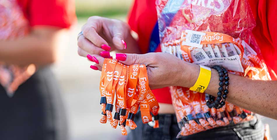 Event staff handing out custom cloth wristbands for festival admission and access control