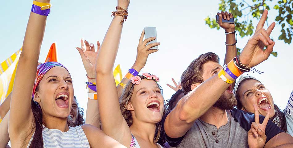 Event crowd wearing colorful vinyl wristbands for secure festival entry, access control, and multi-day admission at a live outdoor concert